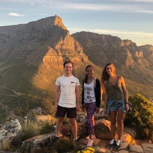 Hikers ascending Lion’s Head with Table Mountain in the background